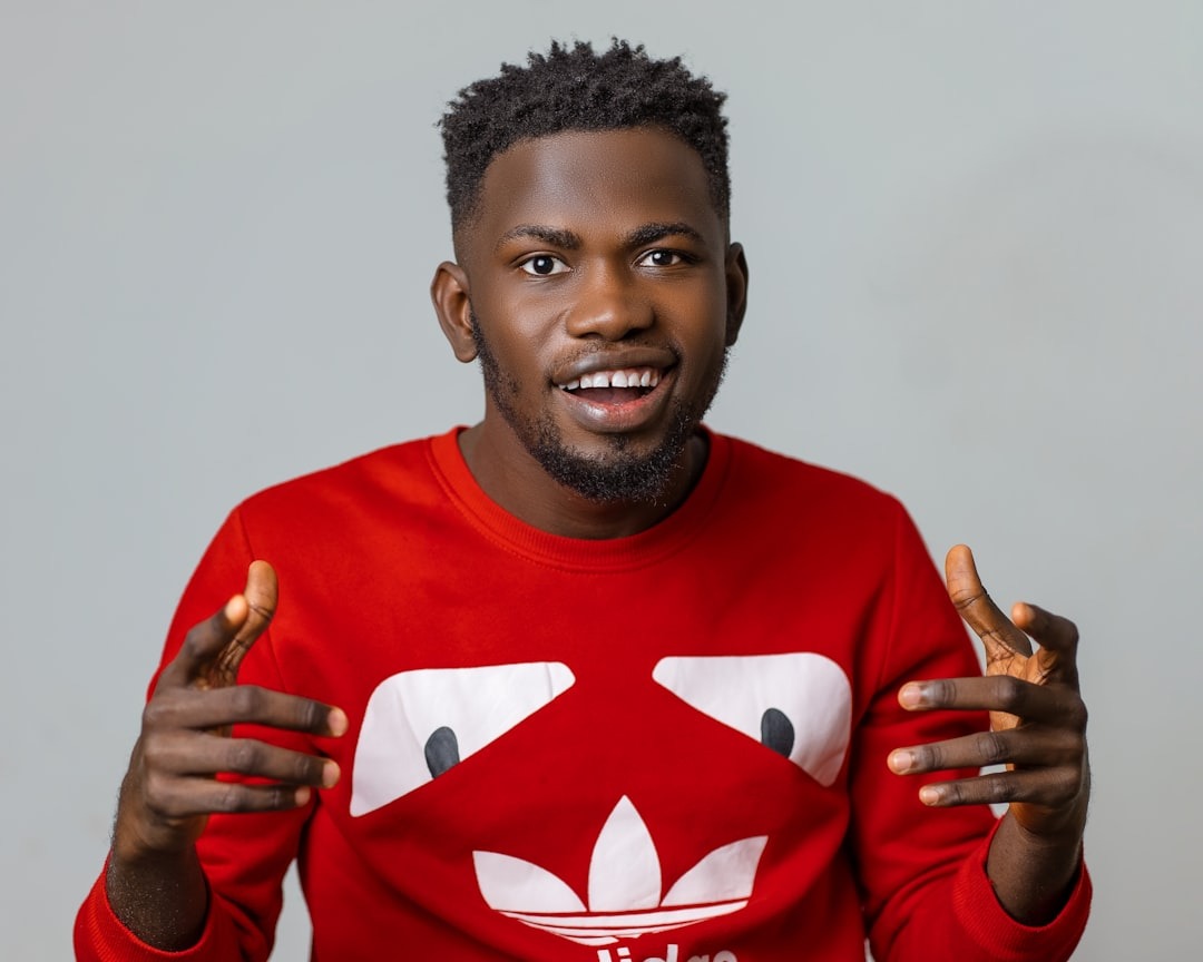 a man in a red shirt holding two fingers up